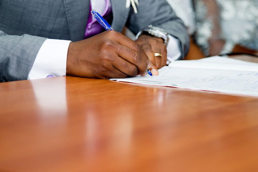 groom signing marriage license after wedding