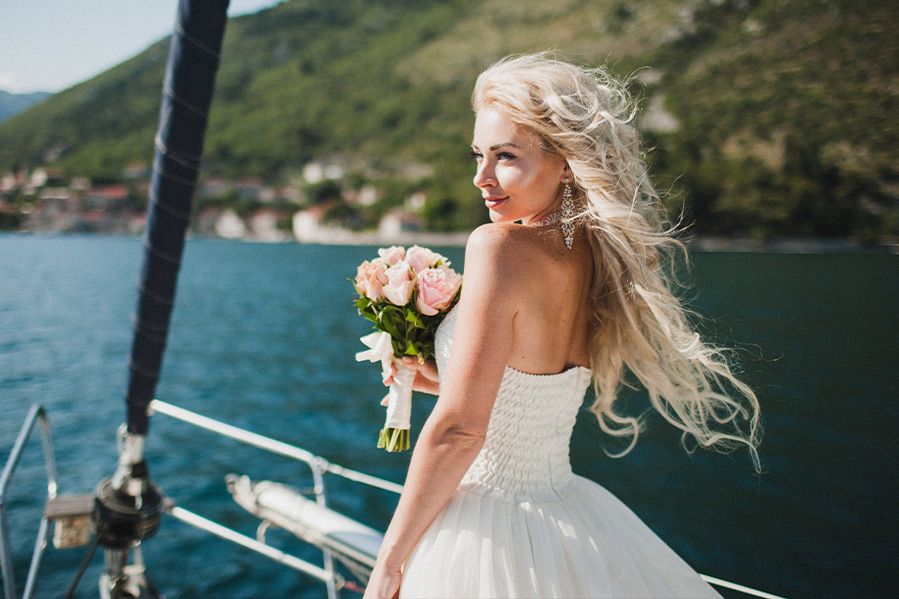 bride holding flowers on boat during wedding at sea