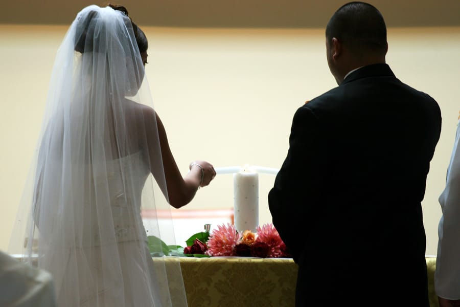 Bride and groom lighting the ceremonial unity candle in candle ceremony